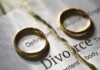 Two wedding rings placed on a torn page with the word Divorce