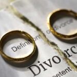 Two wedding rings placed on a torn page with the word Divorce