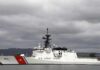 A U.S. Coast Guard ship docked under cloudy skies