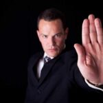 Businessman in a suit making a stop gesture with his hand