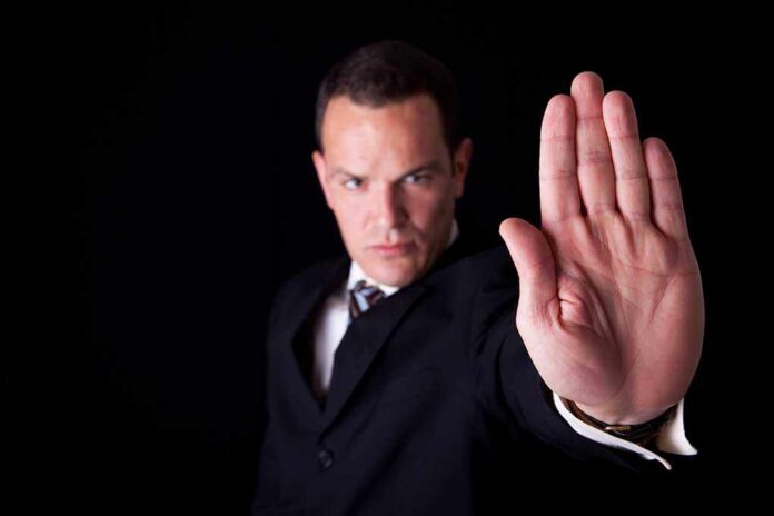 Businessman in a suit making a stop gesture with his hand