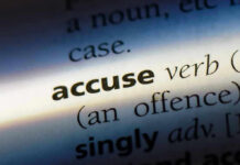 Close-up dictionary definition of accuse underlined.