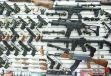 STUNNING Gun BAN — Federal FIRESTORM BREWING Wall display of various firearms in a store.
