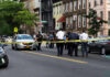 Stabbed Scholars: Chilling Crime Unfolds Police gathered at an urban crime scene.