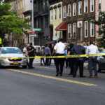 Stabbed Scholars: Chilling Crime Unfolds Police gathered at an urban crime scene.