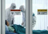 DEADLY Meningitis Cluster Hidden — WHY? Healthcare workers in protective gear in quarantine room.