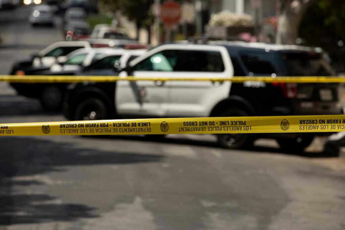 1980603047 Police tape blocking street with patrol cars.