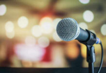 MUSIC INDUSTRY SHAKEN: Face’s Triple Threat! Microphone with blurred lights in the background.