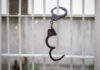 Handcuffs hanging on a barred window.