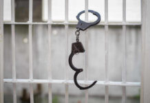 Handcuffs hanging on a barred window.