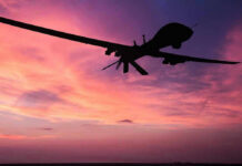 A Battlefield of Swarms, Propaganda, and Rising Global Risks Silhouette of a drone against a colorful sunset.