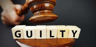 A gavel above wooden blocks spelling 'GUILTY'