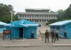 High-Stakes Truce Framework Leaves Major Questions Unanswered Military personnel standing near blue buildings at a border crossing