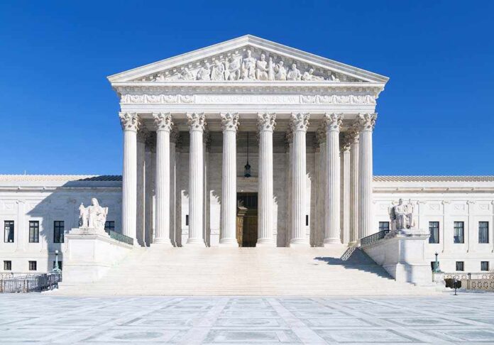 The Supreme Court building featuring marble columns and a clear blue sky