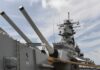 Close-up of a battleships naval guns and superstructure against a cloudy sky