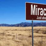 Toddler Climbs from Wreck – Viral Video Chaos! A road sign reading 'Miracles Just ahead' in a desert landscape