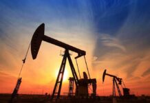 Silhouetted oil pumps against a colorful sunset sky