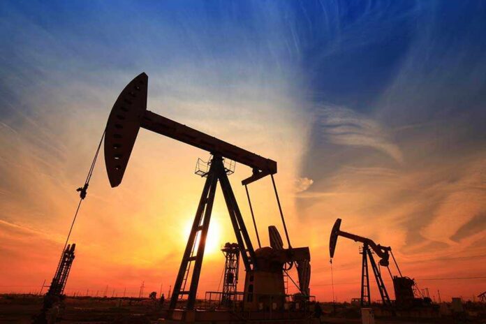 Silhouetted oil pumps against a colorful sunset sky