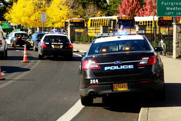117302929-1 Police cars and school buses on a road.
