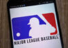 Bible Verse Hats, Big League Backlash Major League Baseball logo on a smartphone screen.