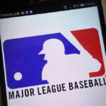Bible Verse Hats, Big League Backlash Major League Baseball logo on a smartphone screen.