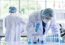 Federal Scientists Accused of Smuggling Virus Samples on Flight Scientists working in a laboratory with test tubes