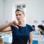 No FISA Renewal Without Voter ID — Standoff Woman with thumbs down in voting location.