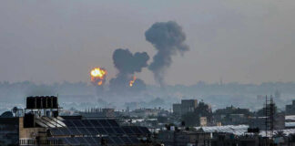 Flames and smoke billowing over a cityscape.