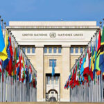 60 Days, Big Gamble United Nations building with numerous national flags outside.