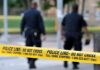 Alleged Domestic Stabbing Death Police officers walking past caution tape at a crime scene