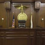 Interior of a courtroom featuring a judges bench and American flag