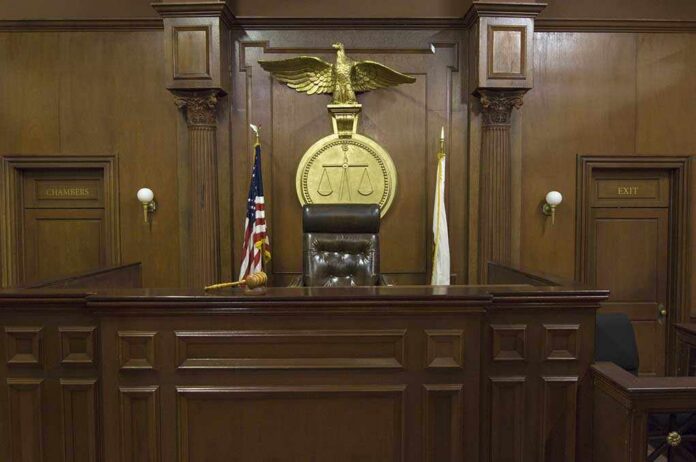 Empty,Courtroom,With,Chair,Of,Judge,And,Flags Interior of a courtroom featuring a judges bench and American flag