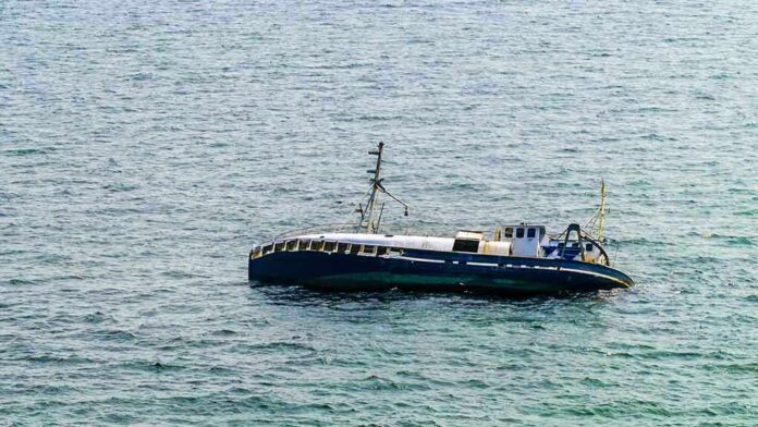 shutterstock_146623823 An abandoned boat floating on the ocean surface