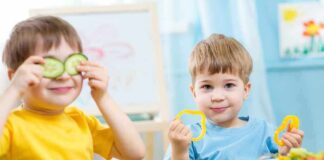 Two children playing with vegetables while enjoying a meal
