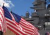 Hellfire Missile Halts Cargo Ship in Gulf of Oman as Naval Tensions Surge American flags in front of a naval ship under a blue sky