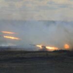Border Erupts: Ceasefire on Life Support A tank firing in a smoky battlefield during a military exercise