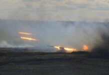 Border Erupts: Ceasefire on Life Support A tank firing in a smoky battlefield during a military exercise