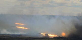 A tank firing in a smoky battlefield during a military exercise