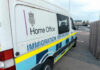 Dad Sues After Feds Track Him Over Anti-ICE Email White immigration enforcement van parked by roadside