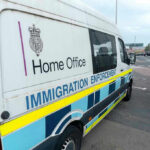 Dad Sues After Feds Track Him Over Anti-ICE Email White immigration enforcement van parked by roadside
