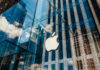 Court Fight Erupts Over Apple’s Claims Apple store with glass facade and city reflections.