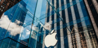 Apple store with glass facade and city reflections.