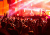 Star-Studded Wedding Reports Put Adam Sandler Center Stage Crowd at concert with vibrant stage lights.
