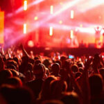 Star-Studded Wedding Reports Put Adam Sandler Center Stage Crowd at concert with vibrant stage lights.