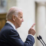 Court Clears Release of Biden’s Memoir Tapes Man in suit pointing while speaking at podium.