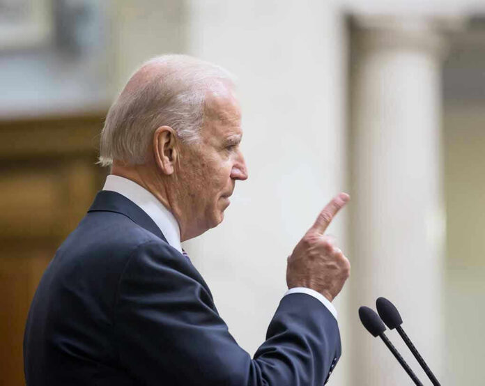 348822887 Man in suit pointing while speaking at podium.