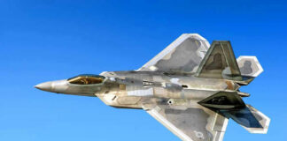Fighter jet in flight against a clear blue sky.