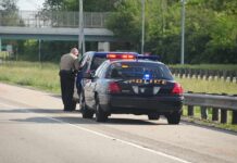 Police Camera Program Suspended Police officer conducting a traffic stop on a highway