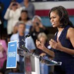 A female speaker passionately addressing a crowd at a campaign event