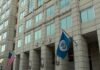 U.S. government building facade with American and blue departmental flags